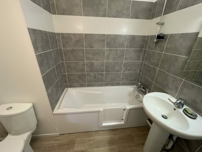 Baignoire avec une ouverture et un portillon anti-eclaboussures